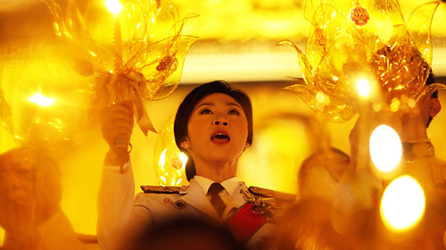 Thai Prime Minister Yingluck Shinawatra holds a candle and sings as she takes part in birthday celebrations for Thailand's revered King Bhumibol Adulyadej in Bangkok, in this December 5, 2013 file picture. To match Special Report THAILAND-POLITICS/ REUTERS/Damir Sagolj/Files (THAILAND - Tags: POLITICS ROYALS)