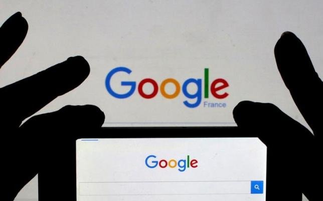 A woman holds her smart phone, which displays the Google home page, in this picture illustration taken February 24, 2016.  REUTERS/Eric Gaillard/Illustration/File Photo